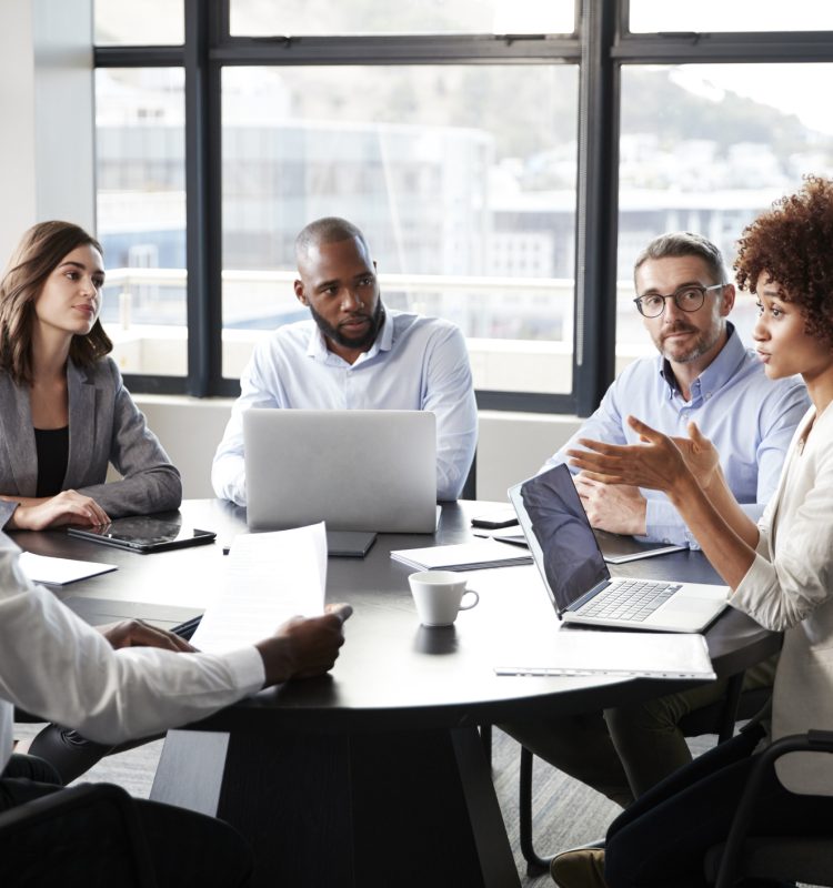 Millennial black businesswoman addressing colleagues at a corporate business meeting, close up